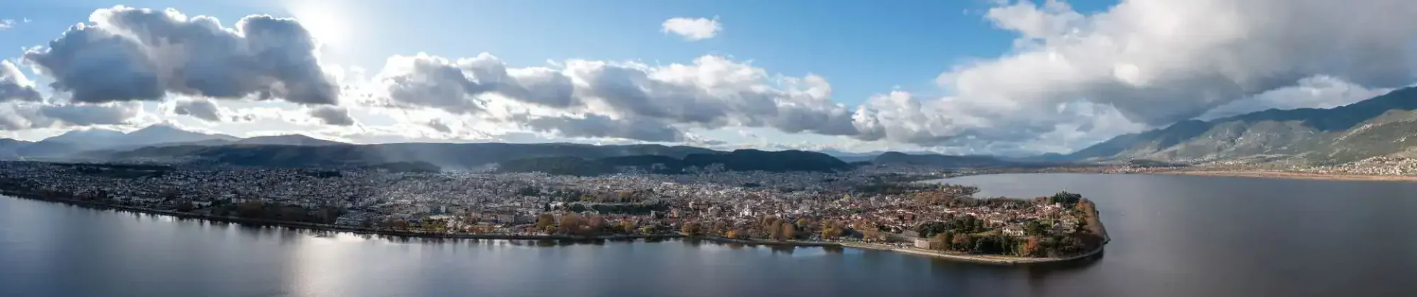 Ανάλυση εικόνας του Τμήματος Ιστορίας και Αρχαιολογίας στο Πανεπιστήμιο Ιωαννίνων, με θέα στη λίμνη.